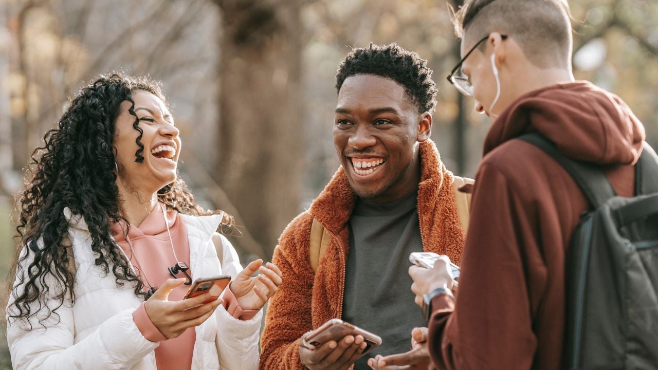 Adult Friendships A group of adult friends outside laughing together.