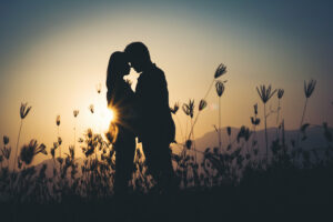 silhouette of a couple in love silhouette during sunset in a field.