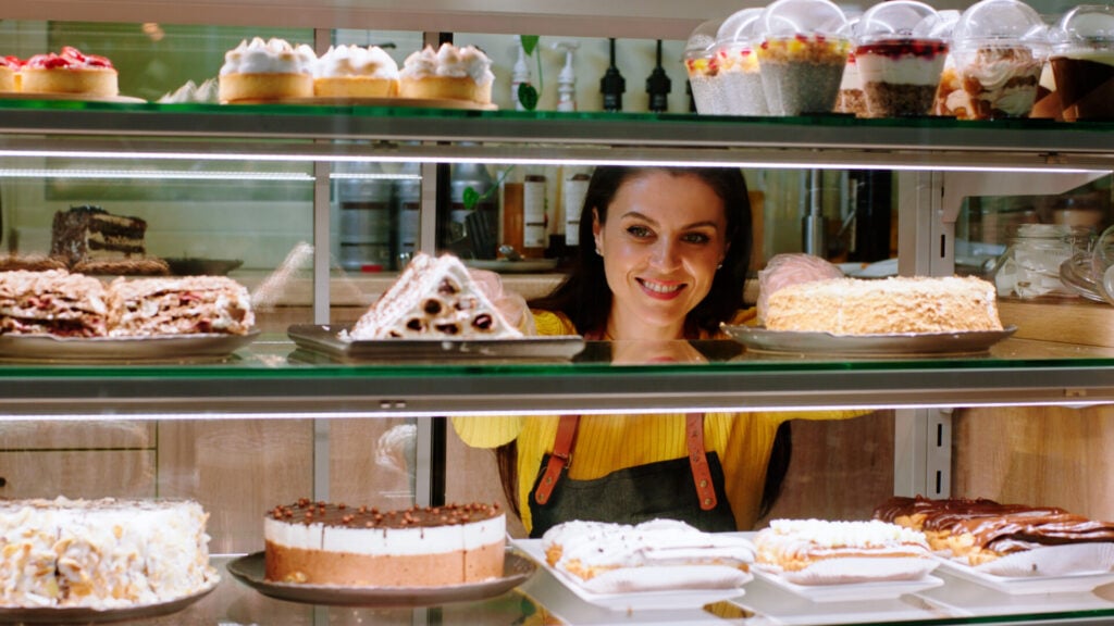 Hard Determinism: Philosophy & Examples (Does Free Will Exist?) 1 A woman looking at shelves of cakes in a bakery while smiling.