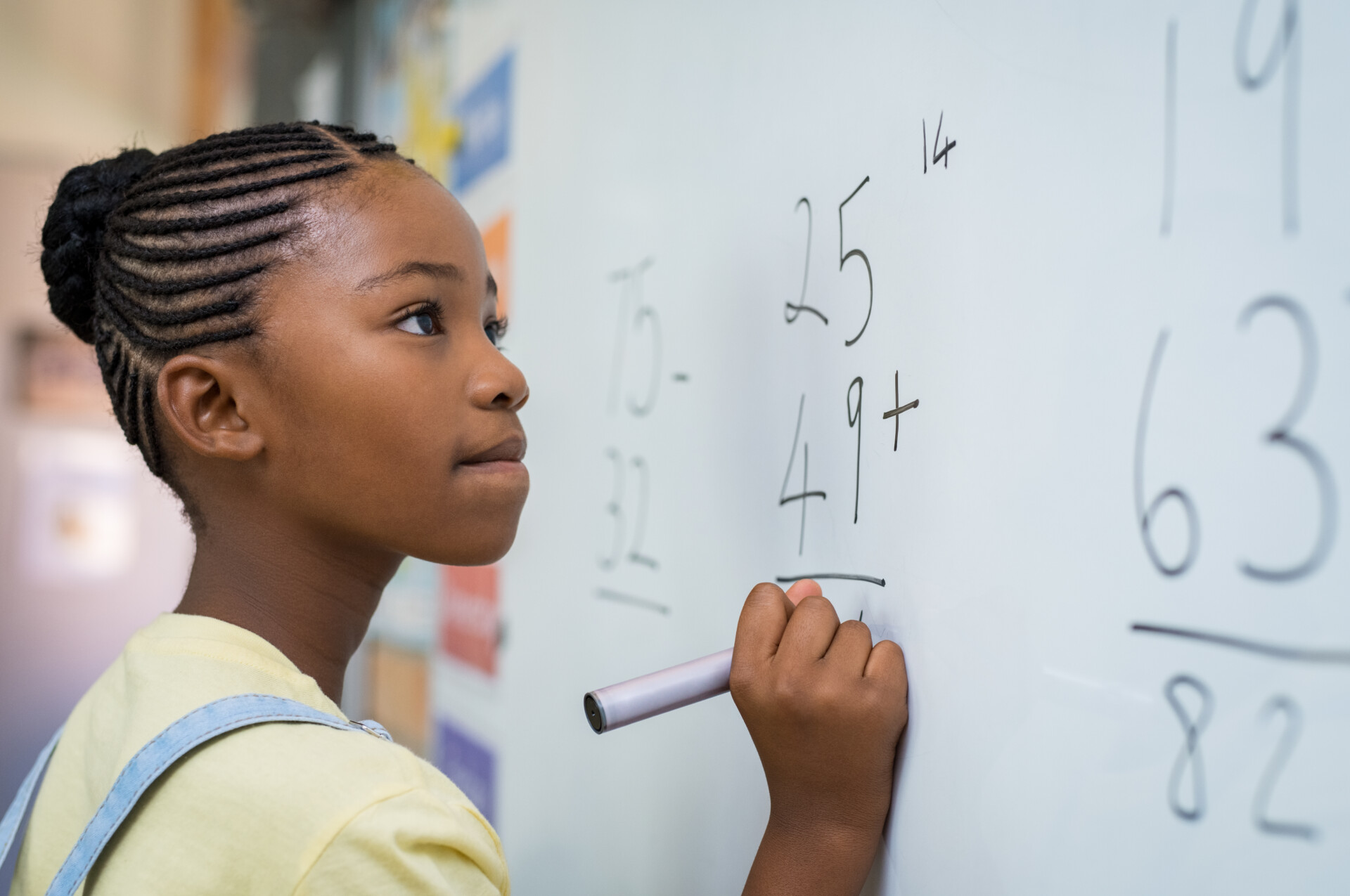 Math Skill ADHD A girl solving a math question on a white board at school.